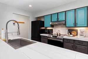 eine Küche mit blauen Schränken und einer Spüle aus Edelstahl in der Unterkunft Stoneridge 41 with Wintergreen Advantage in Wintergreen