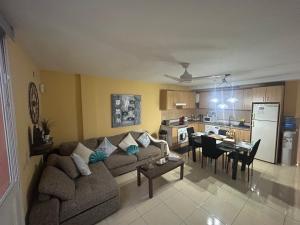 a living room and kitchen with a couch and a table at Casa Gloria in Los Abrigos