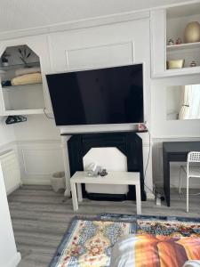 a living room with a flat screen tv above a fireplace at Small Double Room OVO Wembley Stadium in London