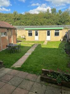 a garden with a table and chairs and a building at Small Double Room OVO Wembley Stadium in London