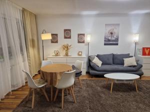 a living room with a blue couch and a table and chairs at Casa Velten in Bühl +6 photos