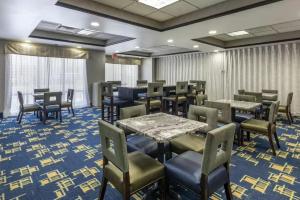 a dining room with tables and chairs on a blue carpet at Comfort Inn & Suites Pauls Valley - City Lake in Pauls Valley