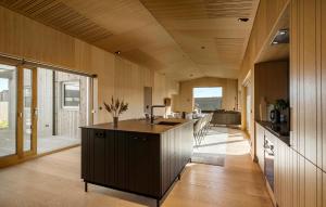 a kitchen with a island in the middle of a room at 6 Bedroom Cozy Home In Løkken in Løkken
