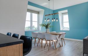 a dining room with blue walls and a table and chairs at Cozy Apartment In Kamperland in Kamperland