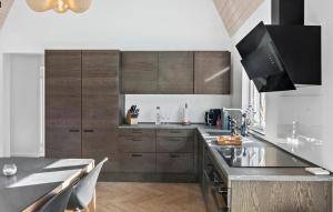 a kitchen with wooden cabinets and a counter top at Lovely Home In Væggerløse With Sauna in Marielyst