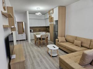 a living room with a couch and a table at EraVision Apartament in Yzberishti