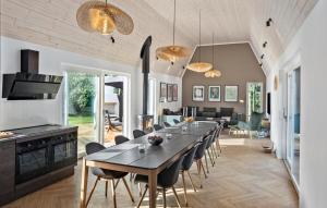 a kitchen and dining room with a long table and chairs at Lovely Home In Væggerløse With Sauna in Marielyst