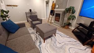 a living room with a couch and a chair and a fireplace at Piña Pecan House by Palace of Nobles in Charlotte