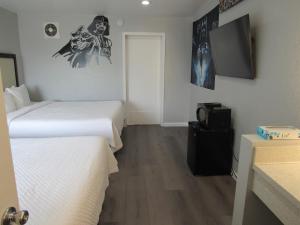 アナハイムにあるCapri Suites Anaheimのベッド2台とテレビがあるホテルの部屋