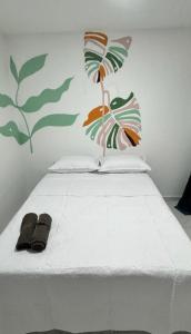 a white bed with two slippers on top of it at Hotel Stay Golden in Cartagena de Indias +8 photos