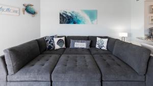 a gray couch in a living room with pillows at Blue Haven Key LargoOcean Pointe 1315 in Key Largo