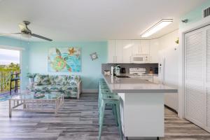 a kitchen with white cabinets and a blue wall at Paradise Palms Ocean Pointe 1206 in Key Largo