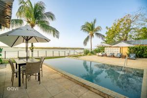 皮帕Qavi - Lagoa View的游泳池旁带遮阳伞的桌子