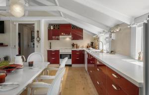 cocina con armarios rojos y encimera blanca en Pet Friendly Home In Blokhus With Wifi, en Blokhus