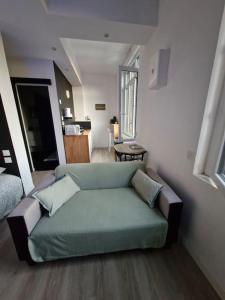 a living room with a green couch in a room at Studio Canada 3 in Valenciennes
