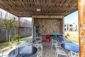 patio ze stołami i krzesłami oraz kamienną ścianą w obiekcie Qavi - Villas Patacho na Rota ecológica de Milagres w mieście Tatuamunha
