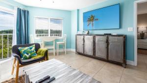 a living room with blue walls and a table at Boho Chic Ocean Pointe 3214 in Key Largo