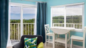 a room with a table and chairs and a balcony at Boho Chic Ocean Pointe 3214 in Key Largo