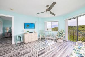 a living room with blue walls and a ceiling fan at Paradise Palms Ocean Pointe 1206 in Key Largo