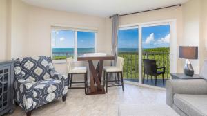 un soggiorno con tavolo e sedie e un balcone di Ocean View Gem Ocean Pointe 3406 a Key Largo
