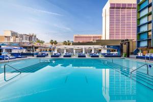 a large swimming pool with chairs and a building at The LINQ Hotel and Casino in Las Vegas