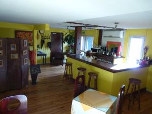 a kitchen with yellow walls and a bar with stools at Ad Cyber-Hôtel in LʼUnion