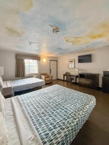 a bedroom with two beds and a ceiling with a bird on the ceiling at Super 7 Motel - Anaheim Packing District & Disneyland in Anaheim