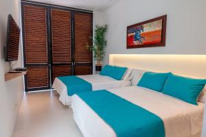 two beds in a hotel room with blue and white at Iguá Casas de Campo - Anapoima in Anapoima