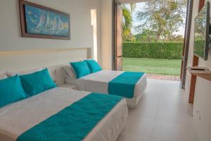 two beds in a room with a view of a yard at Iguá Casas de Campo - Anapoima in Anapoima +21 photos
