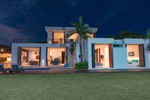 a large white house with a lawn in front of it at Iguá Casas de Campo - Anapoima in Anapoima