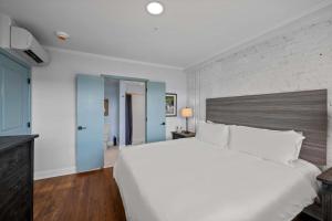 a bedroom with a large white bed and a brick wall at Discover Conway Trendy Downtown Loft in Conway