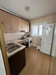 a kitchen with a sink and a white refrigerator at Apartamento los jazmines in Roquetas de Mar