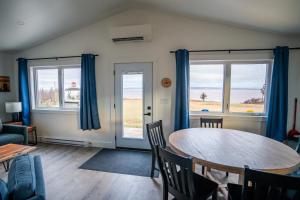 a living room with a table and two windows at Shangri-La Cottages in Burntcoat