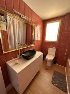 a red tiled bathroom with a sink and a toilet at Apartamento los jazmines in Roquetas de Mar