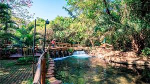 a bridge over a river in a park at Apartamento de 4 Quartos Cobertura Com Área de Lazer in Rio Quente