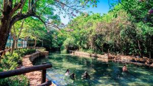 a group of people swimming in a river at Apartamento de 4 Quartos Cobertura Com Área de Lazer in Rio Quente