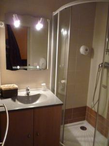 La salle de bains est pourvue d'une douche et d'un lavabo. dans l'établissement Ad Cyber-Hôtel, à LʼUnion