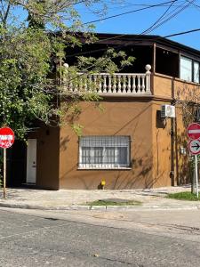 a brown building with a window and a balcony at Hospedaje Umma2-Ezeiza in Ezeiza