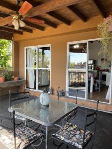 a patio with a table and chairs and windows at Hospedaje Umma2-Ezeiza in Ezeiza