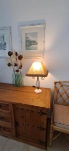 a lamp on top of a wooden desk with a chair at Apartamento Neptuno in Benagil