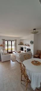 a living room with a table and chairs and a living room at Apartamento Neptuno in Benagil