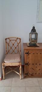 a chair next to a wooden cabinet and a lantern at Apartamento Neptuno in Benagil