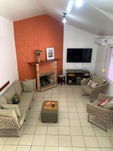 a living room with a couch and a tv at Casa Jardim Garopaba in Garopaba +5 photos