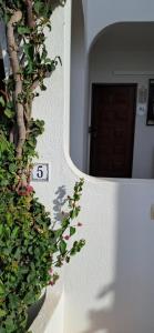a wall with a number sign and some plants at Apartamento Neptuno in Benagil