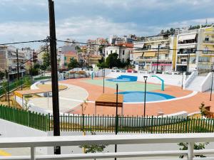 vista su un parco giochi in una città con edifici di The Romantic Traveller a Kavala