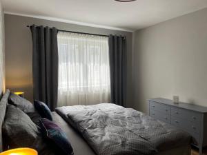 a bedroom with a bed and a window at Apartmán v centre mesta in Žilina