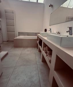 łazienka z 2 umywalkami i wanną w obiekcie Loft duplex and rooftop w mieście Roubaix
