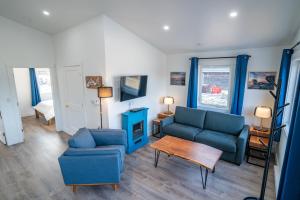 a living room with two blue couches and a table at Shangri-La Cottages in Burntcoat