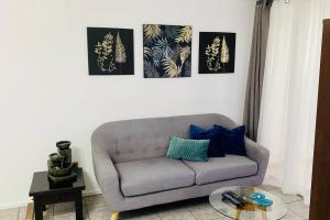 a living room with a gray couch and four pictures at Portada VIP in La Chimba