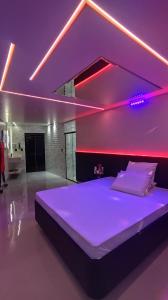a bedroom with a large bed with purple lighting at Vem Para o - Motel Marselha 3 in Sao Paulo